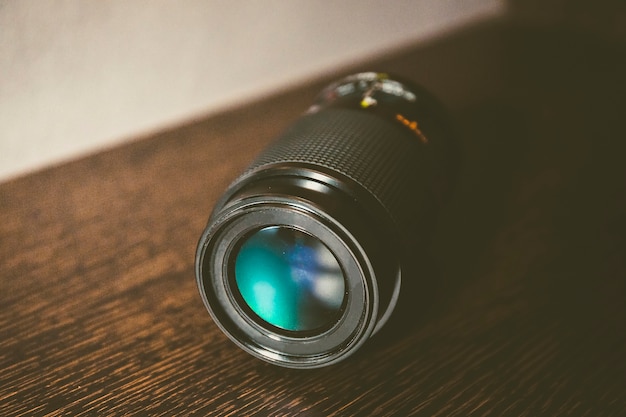 Foto la vida inmóvil de una lente de cámara en un pedazo de madera con color degrada