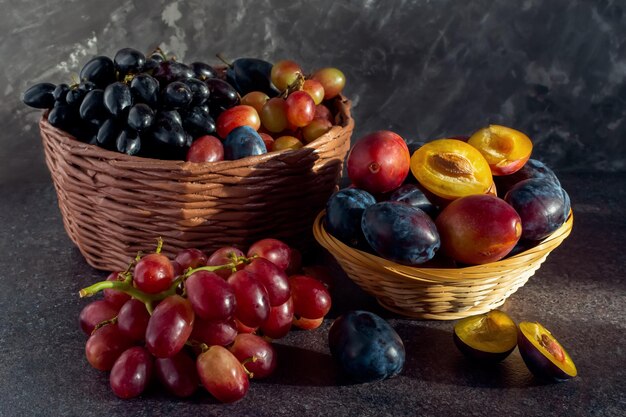 Foto vida morta de uvas e ameixas em uma cesta