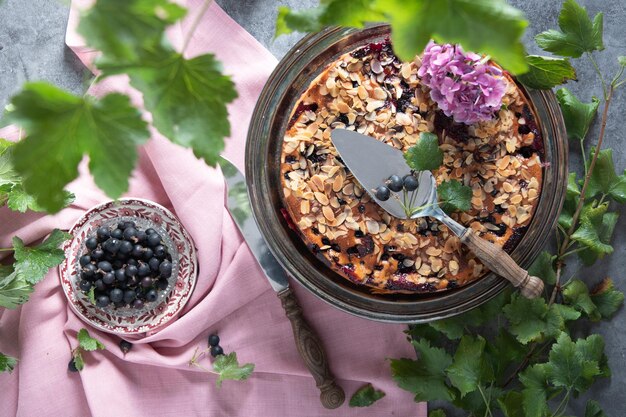 Foto vida muerta con deliciosa tarta de bayas con almendras y grosella negra horneada