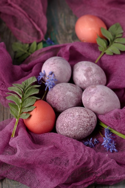 Vida muerta de hermosos huevos púrpuras con textura en gasa púrpura