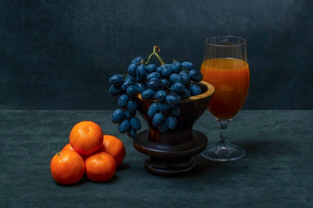 Vida muerta con mandarinas uvas y jugo de naranja