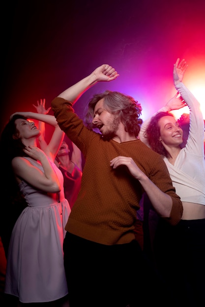 Vida nocturna con gente bailando en un club.