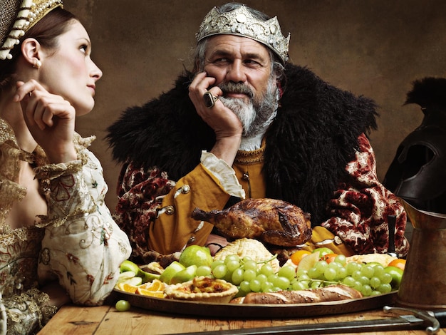 La vida real puede ser tediosa Una reina aburrida sentada junto a su esposo en un banquete