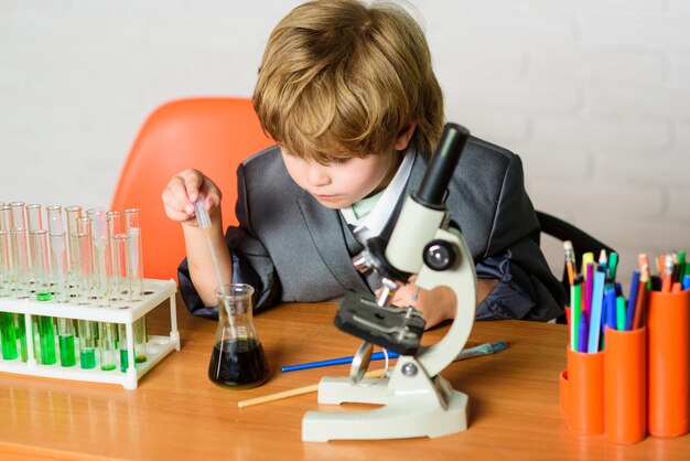 Vida sob microscópio experimentos científicos com microscópio na escola de laboratório garoto cientista estudando ciência garotinho é fazer experimentos científicos biologia ciência garotinho na lição de volta à escola