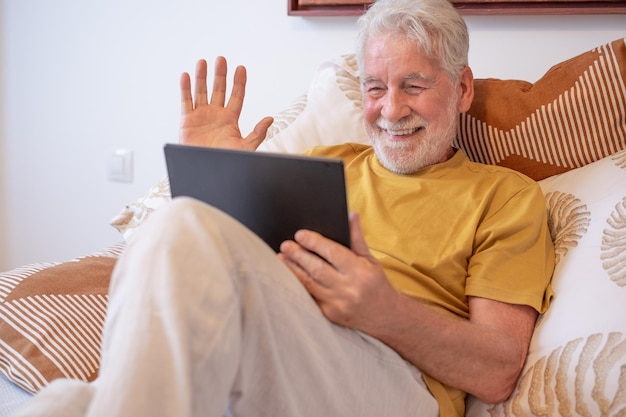 Video-Anruf-Konzept Porträt eines glücklichen älteren bärtigen Mannes, der in einem Remote-Chat mit seiner Familie kommuniziert