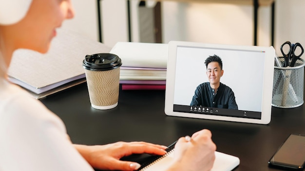 Foto video-beratung business-coaching-studentin beim schreiben von notizen nach einem fachmann auf