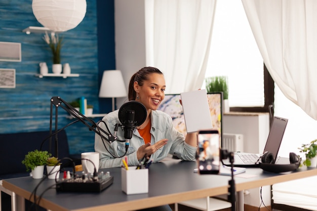 Vídeo blogger gravando talk show em podcast de home studio usando equipamentos modernos. vlogger criador de conteúdo criativo e influenciador que cria séries online com distribuição de brindes para o público.