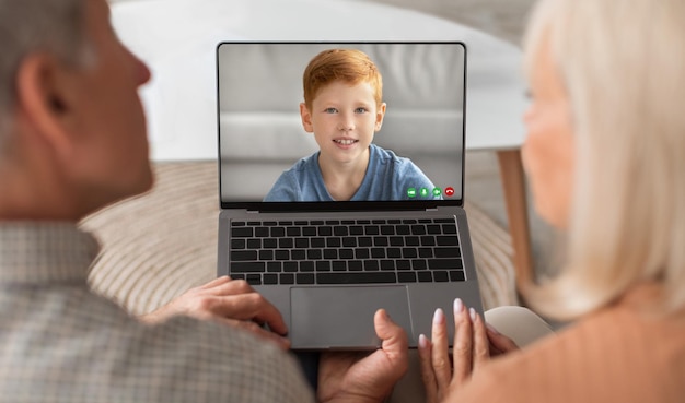 Videoanruf Großeltern machen Webkonferenz mit Enkel auf Laptop zu Hause