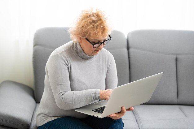 Videoanruf. Gut aussehende ältere Dame, die ich einen Videoanruf auf dem Laptop habe