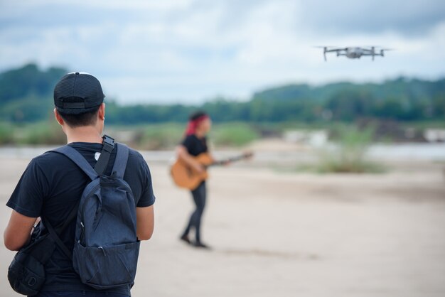 Videoaufzeichnung mit einem Drohnenflugzeug Asiatische Männer verwenden Videodrohnen, um Musikvideos zu erstellen