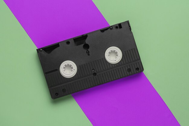 Videocassete retrô em um fundo verde-roxo. anos 80. vista do topo