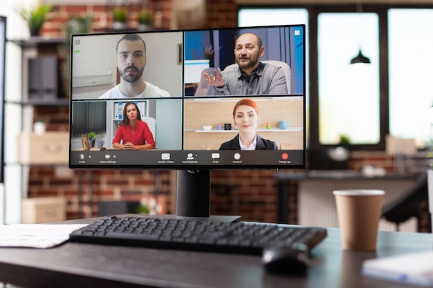 Foto videochamada de negócios com a equipe de colegas de trabalho no computador no escritório vazio de inicialização. monitore com videoconferência remota online, usado para reuniões da empresa com empresários na mesa.