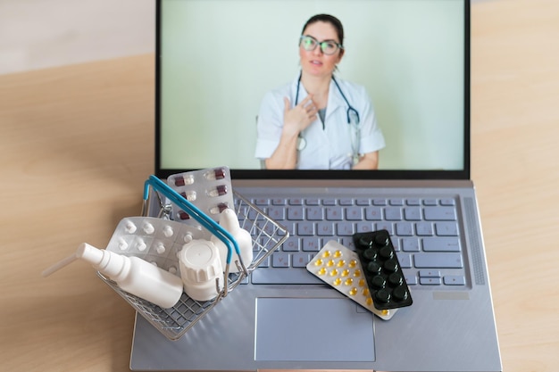 Videoconferencia con un médico en una computadora portátil y una tableta en una pequeña canasta de compras Farmacia en línea Farmacéutico en una pantalla de computadora
