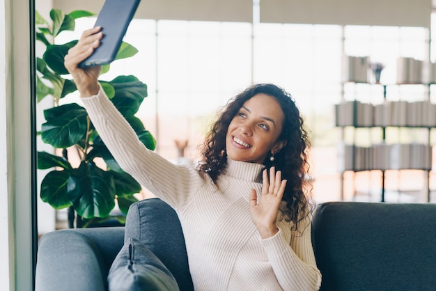 Foto videoconferencia de mujer latina en tableta con sentimiento feliz