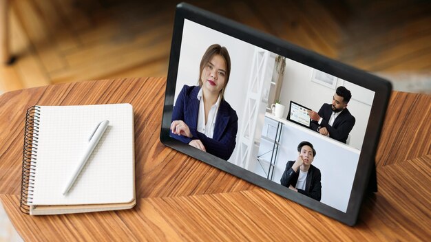 Videoconferencia Tecnología de la FMH Teletrabajo profesional Diversos empresarios viendo una presentación en línea en una oficina digital en la pantalla de una tableta