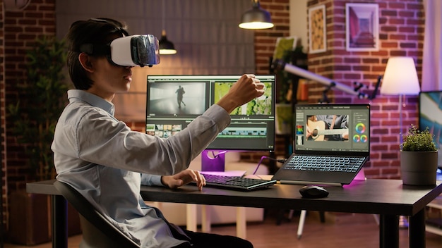 Videofilmer, der vr-brillen und bearbeitungssoftware auf dem pc verwendet, um visuelle effekte auf videomontage, augmented reality zu erstellen. Filmmaterial bearbeiten mit 3D-Headset und Film auf dem Computer. .