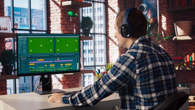 Videograf, der professionell Clips mit einem Green-Screen-Computer anpasst
