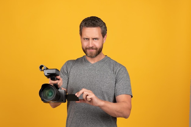 Videógrafo de homem barbudo sorridente fazendo filme para vlog com cinegrafista de filmadora