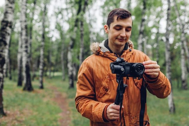 Videographer, der Frühlingswald filmt Mann, der Steadicam und Kamera verwendet, um Gesamtlänge zu machen