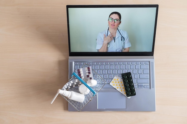 Videokonferenz mit einem Arzt auf einem Laptop und einem Tablet in einem kleinen Warenkorb Online-Apotheke Apotheker auf einem Computerbildschirm