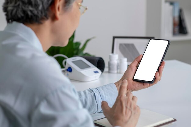 Videollamada mujer asiática usando un teléfono inteligente con pantalla blanca en blanco en casaxD