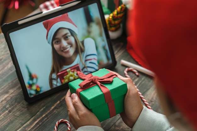 Videollamada de navidad y año nuevo con un amigo con regalo de intercambio de tableta juntos en casa
