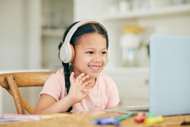 Videollamada portátil y niño en tecnología de audio de auriculares y clase en línea para educación en el hogar o aprendizaje electrónico Saludo de la escuela virtual y alumna escuchando en la computadora en la plataforma de enseñanza