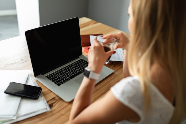 Videollamada, videoconferencia con otras personas en una computadora portátil en el interior. Aprendizaje y trabajo online. Mujer con ordenador portátil trabajando en la oficina en casa