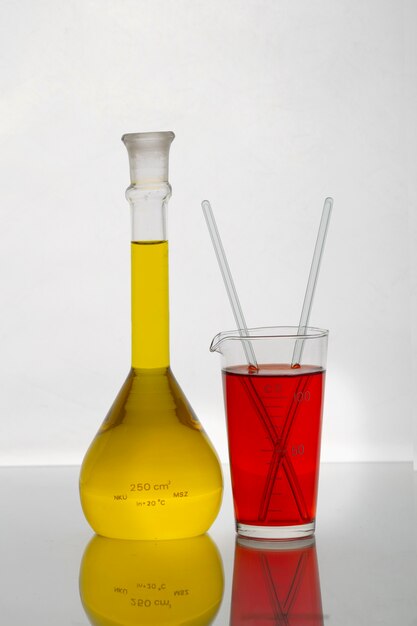Foto vidraria de laboratório com líquido colorido e fundo branco