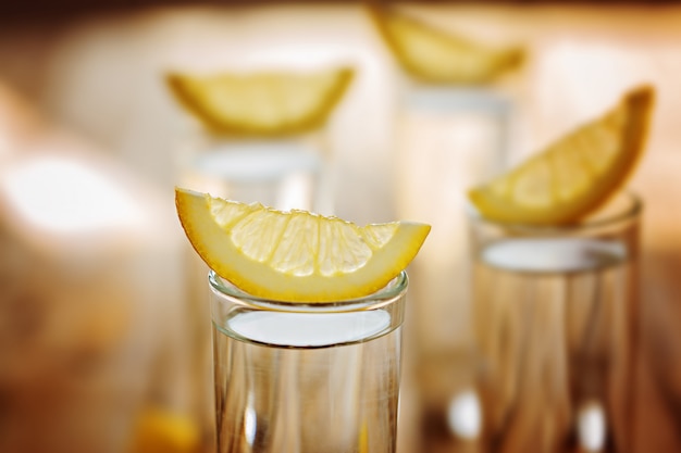 Vidrio frío del primer de vodka con el limón.