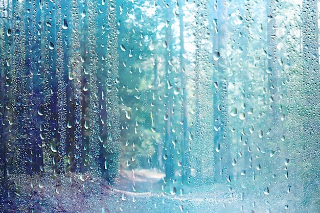 vidrio húmedo de lluvia de verano / paisaje de fondo abstracto en un día lluvioso fuera de la ventana fondo borroso