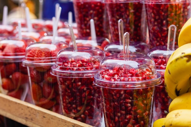 Vidrio de plástico de granada y fresa en el mercado de frutas en la calle en la ciudad de Estambul, Turquía