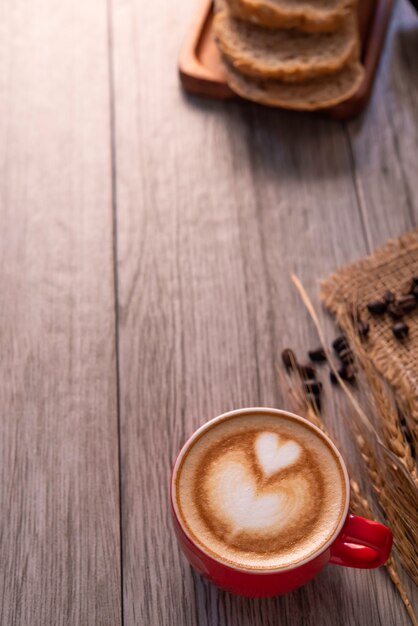 El vidrio rojo del café descansa sobre el piso de madera. concepto bodegón