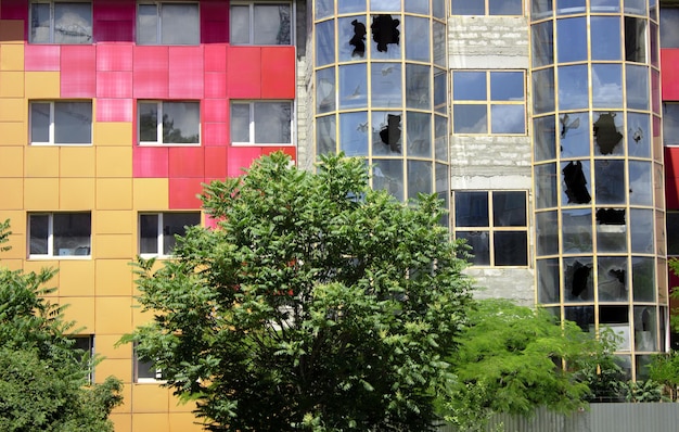 Vidrio roto de un edificio de oficinas. Edificio comercial moderno con ventanas rotas