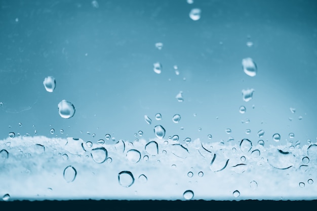 Vidrio de ventana con gotas congeladas de lluvia. gotas heladas de cerca. textura de aguamarina transparente detallada en macro con espacio de copia.