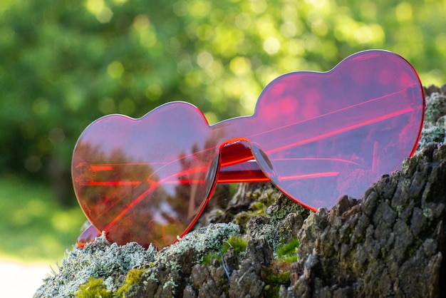 Vidrios rojos bajo la forma de corazones en un fondo natural