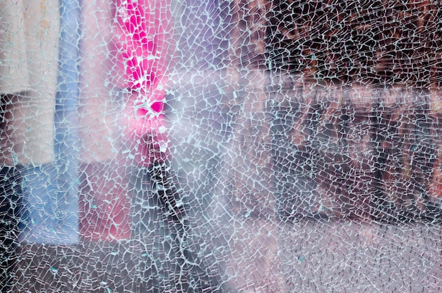 Vidrios rotos de un escaparate de una tienda de ropa con fondo desenfocado