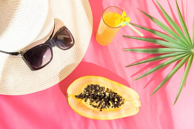 Vidro alto dos óculos de sol do chapéu de palha com folha de palmeira da papaia do suco de fruta tropical