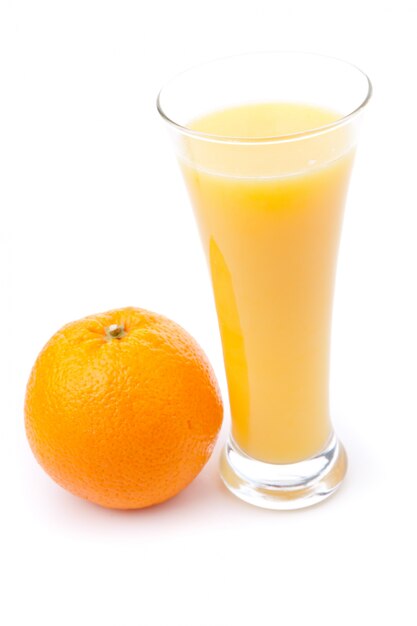 Vidro cheio de suco de laranja colocado perto de uma laranja