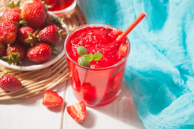 Vidro com chá gelado doce de morango caseiro fresco ou coquetel, limonada com hortelã. Bebida refrescante e fria. Festa de Verão.