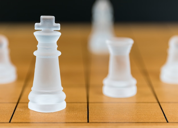 Vidro de xadrez em um tabuleiro de xadrez de madeira