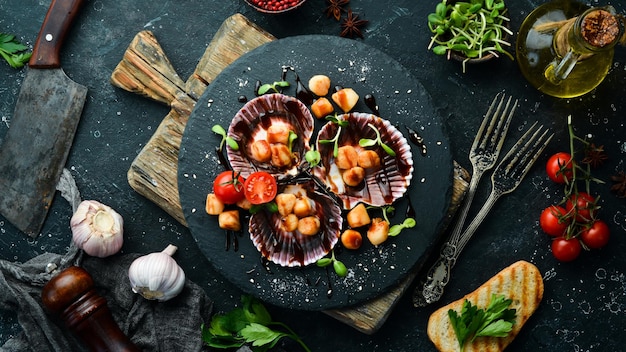 Vieiras al horno con conchas con verduras en un plato de piedra negra Comida de restaurante de lujo Mariscos Estilo rústico Flat Lay