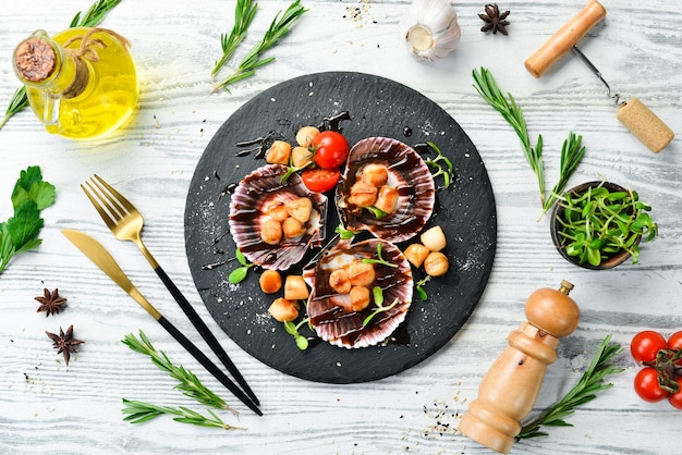 Vieiras al horno con conchas con verduras en un plato de piedra negra Comida de restaurante de lujo Mariscos Estilo rústico Flat Lay