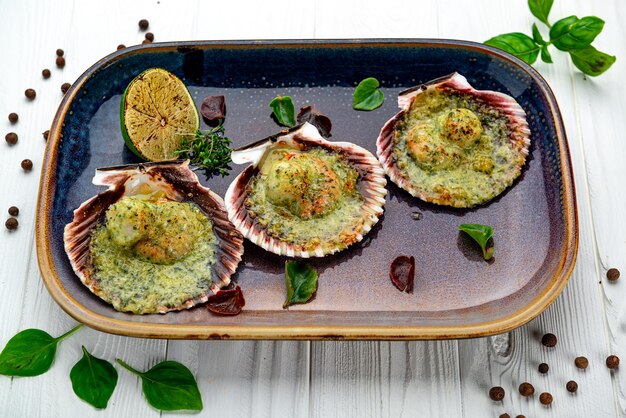 Vieiras assadas na casca com queijo e molho pesto