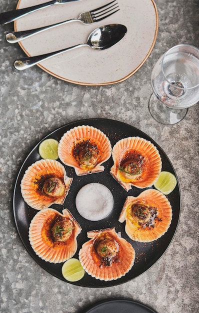 Vieiras com conchas inflamadas em uma placa preta Comida de restaurante de luxo Frutos do mar Vieiras frescas inflamadas