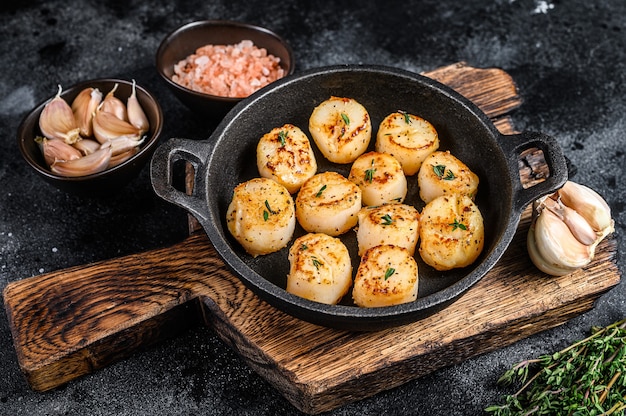 Vieiras fritas con salsa de mantequilla en una sartén.