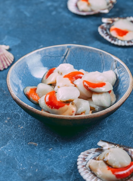 Foto vieiras de mariscos frescos crudos sobre fondo azul