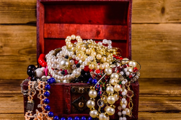Vieja caja de madera roja llena de joyas Cofre del tesoro