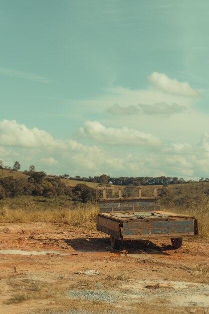 Una vieja cama oxidada se sienta en un campo con un cielo nublado en el fondo.