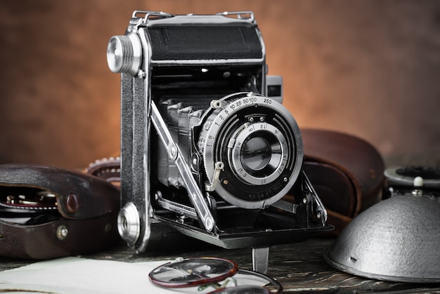 Foto vieja cámara sobre un fondo antiguo en una mesa de primer plano